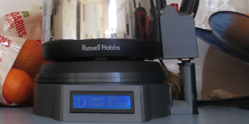 A 3D printed attachment surrounding the kettle handle, connected to the enclosure base